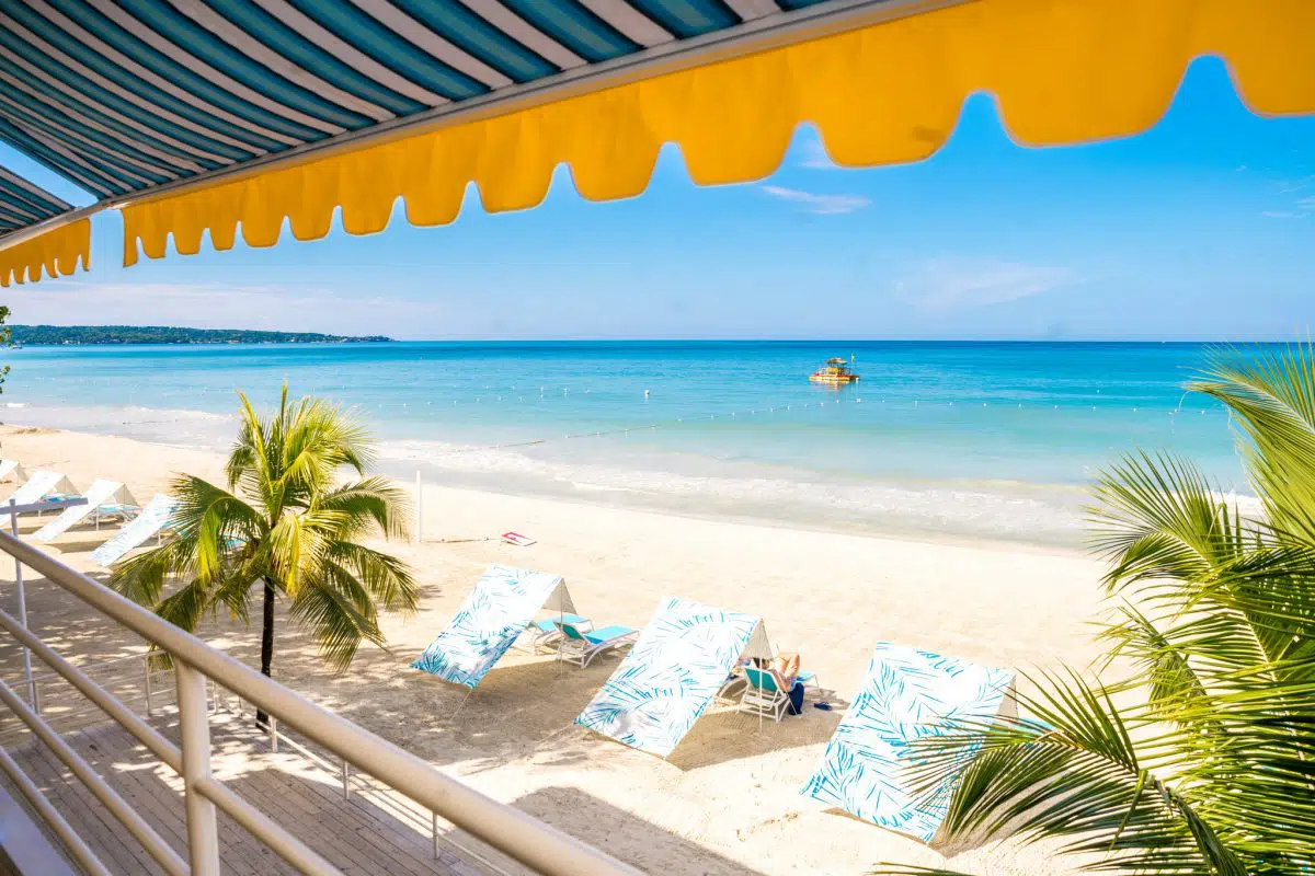 Beach view from Skylark balcony with yellow awning and turquoise sea