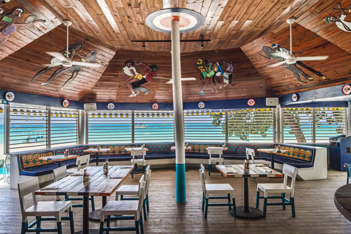 Open-air beachfront restaurant at Skylark with painted ceiling murals and ocean view