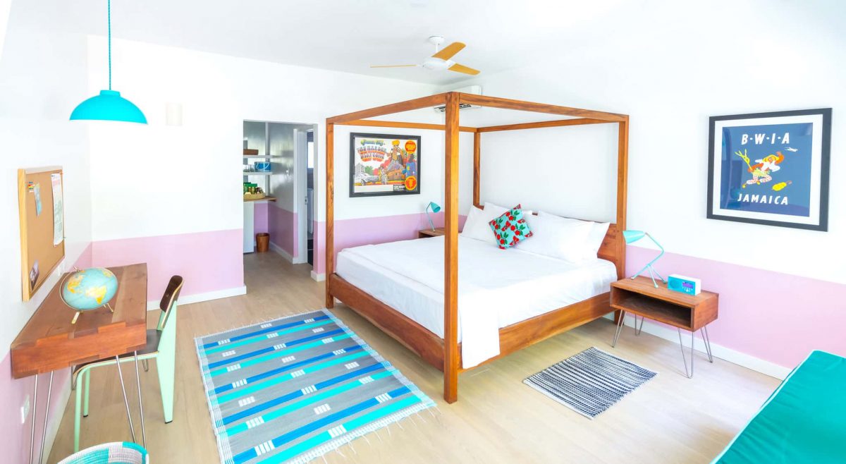 Skylark suite with four-poster bed, pink half-wall and mid-century furnishings